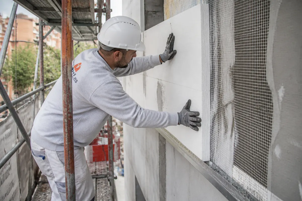 Colocación de placas de aislamiento por el exterior en fachada residencial durante rehabilitación energética