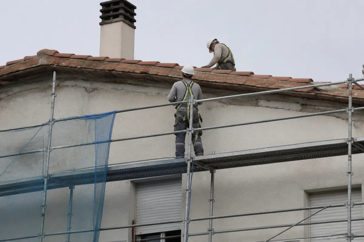 Fachada de edificio residencial en proceso de rehabilitación con andamio y protecciones en entorno urbano de Valencia